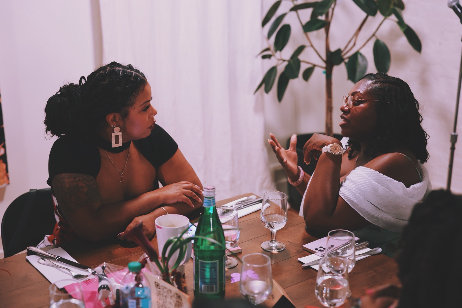 Two guests talking at a long-table dinner